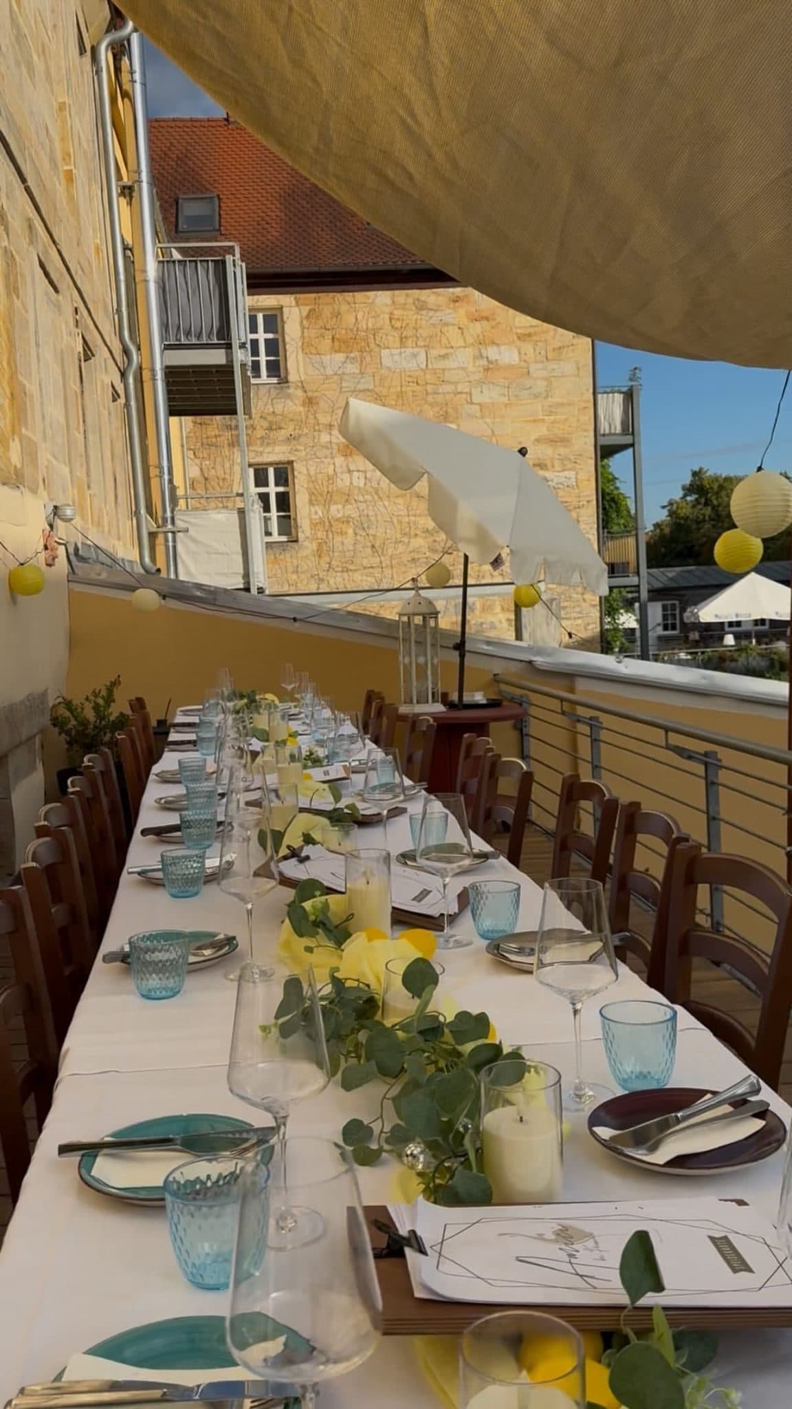 Lange gedeckte Tafel auf der Terrasse der Trattoria Amici an einem Sommerabend
